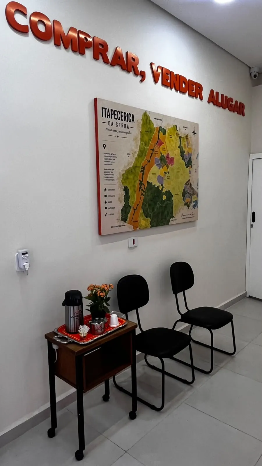 Espera da Conectta, com o mapa da região na parede e café à disposição